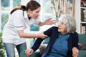 A nurse shouting at a scared elderly.